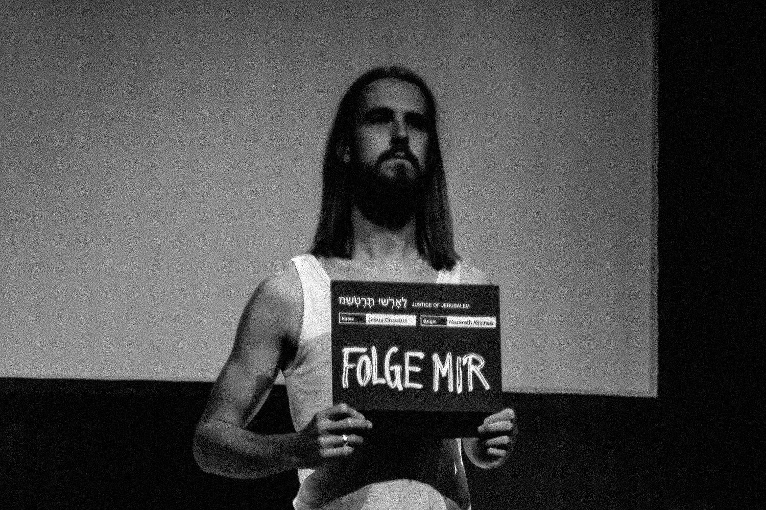 Mann hält ein Schild mit der Aufschrift »Folge mir«